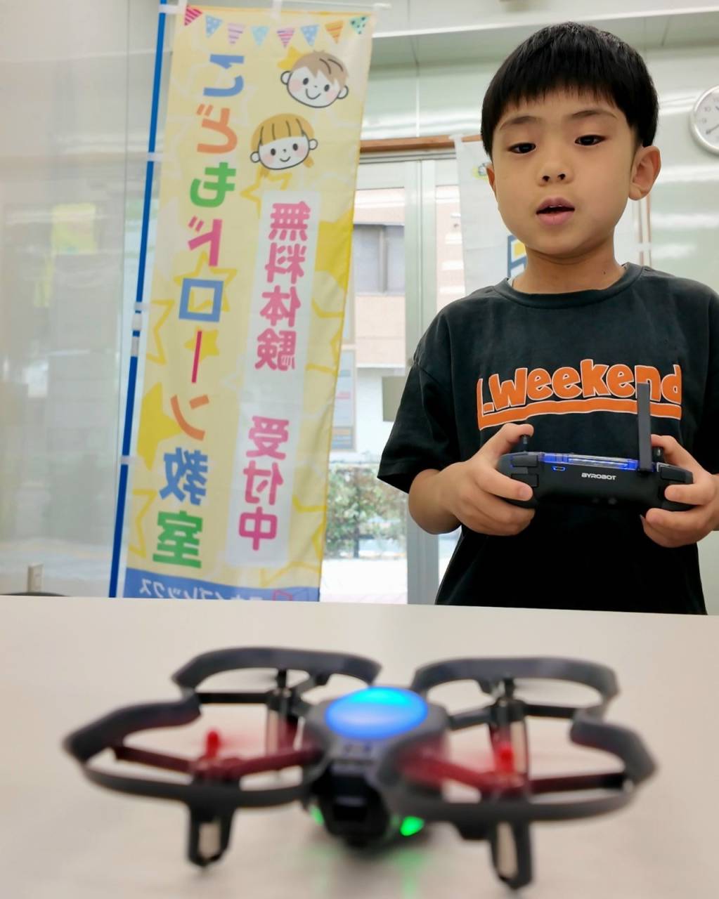 小学生がプロポを操作してドローンを離陸させる様子（東京都荒川区西尾久）