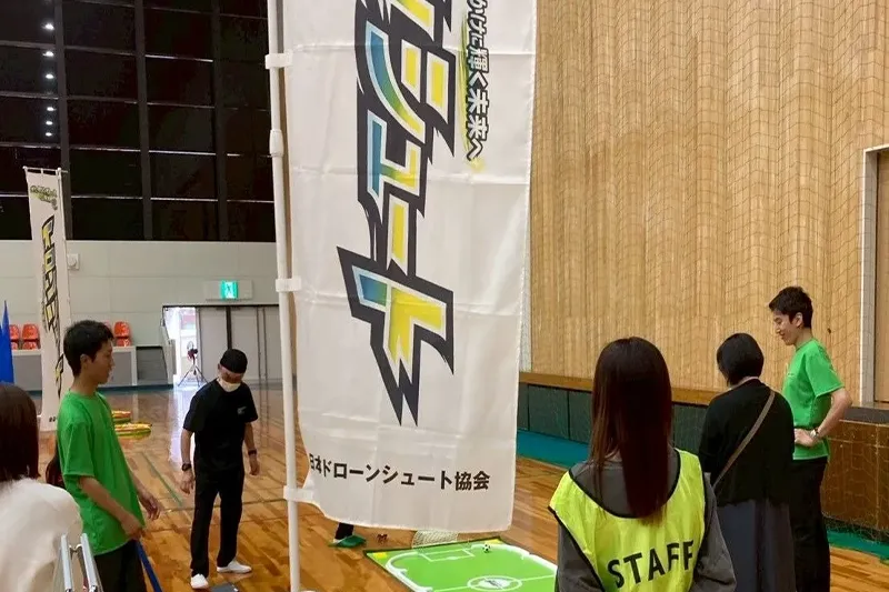 イベント会場に出展したドローンシュートのブースと運営スタッフ